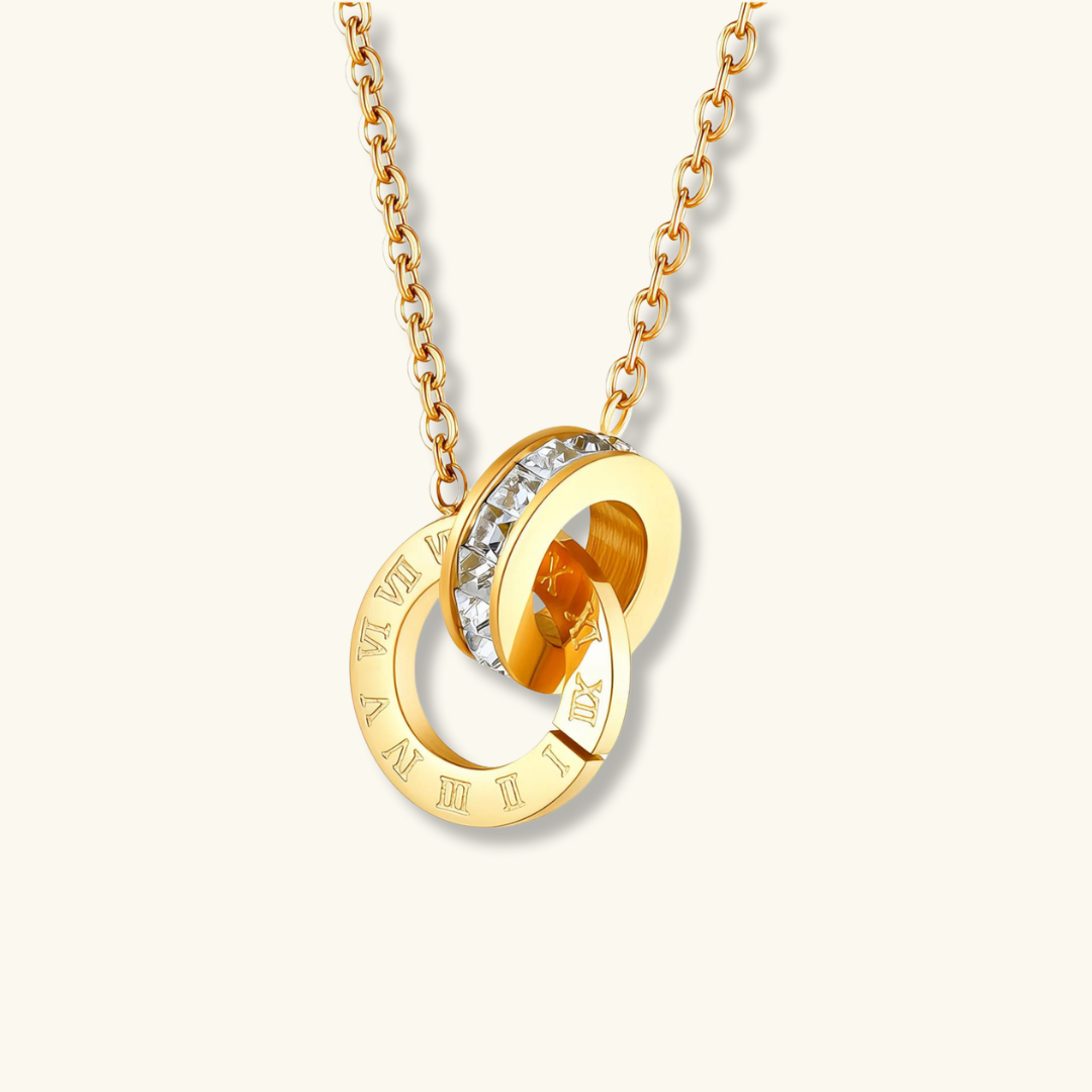 Gold necklace with interlocking rings and embedded gemstones on a white background