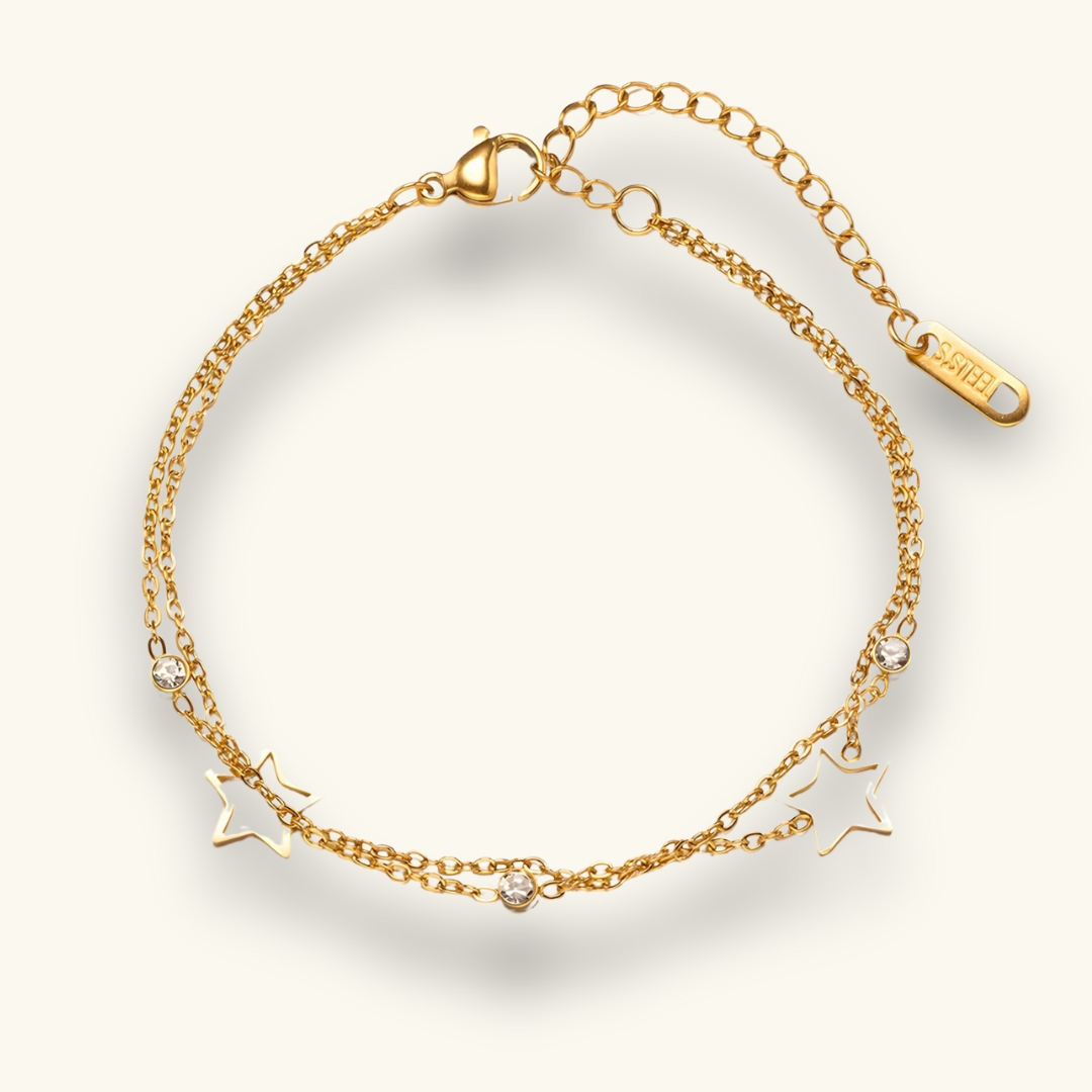 A gold-colored double chain bracelet with star charms and small cubic zirconia stones, displayed against a white background
