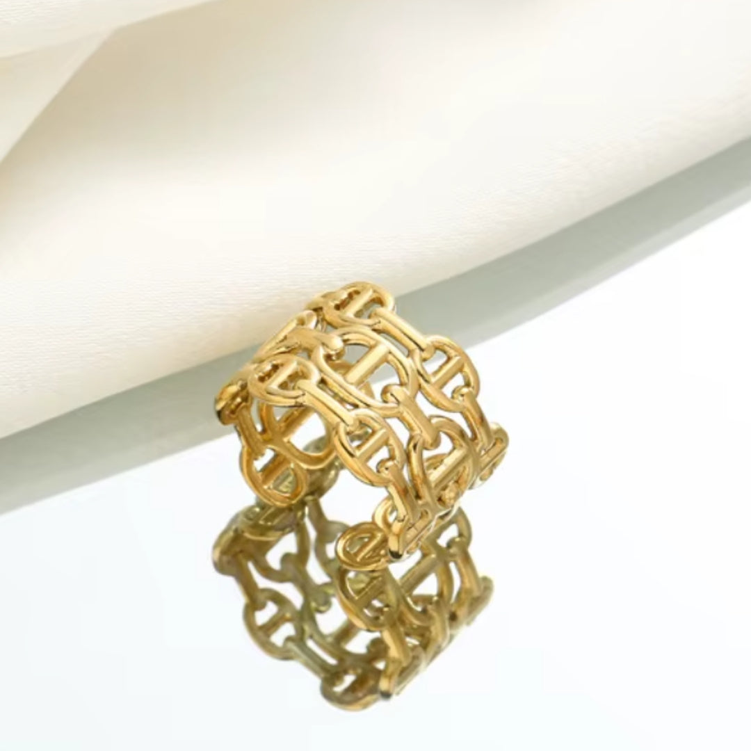 Gold ring with intricate design on a white background