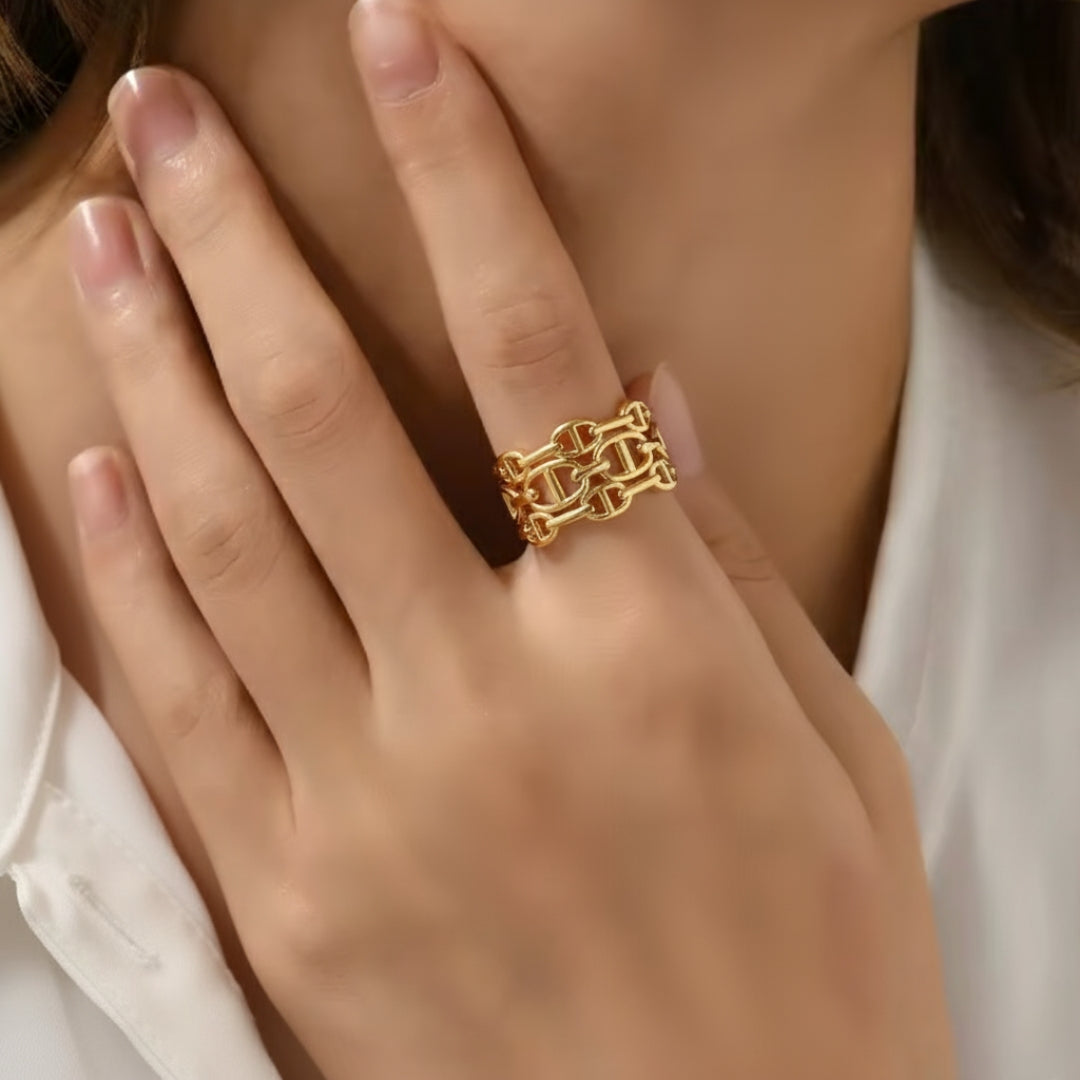 Gold chain ring on a hand with a blurred background