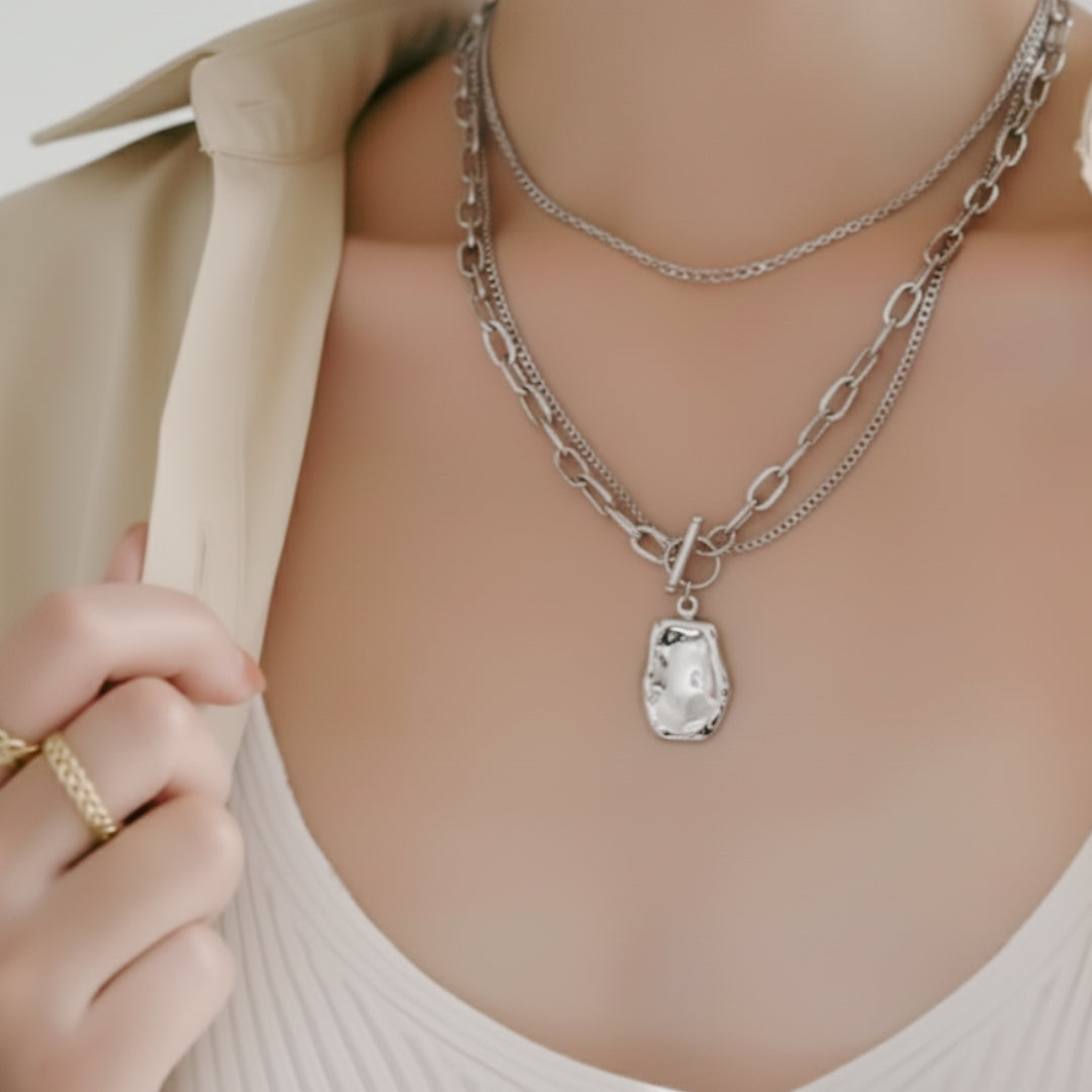 Silver Necklace with a pendant worn by a person, with a neutral background