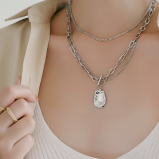 Silver Necklace with a pendant worn by a person, with a neutral background