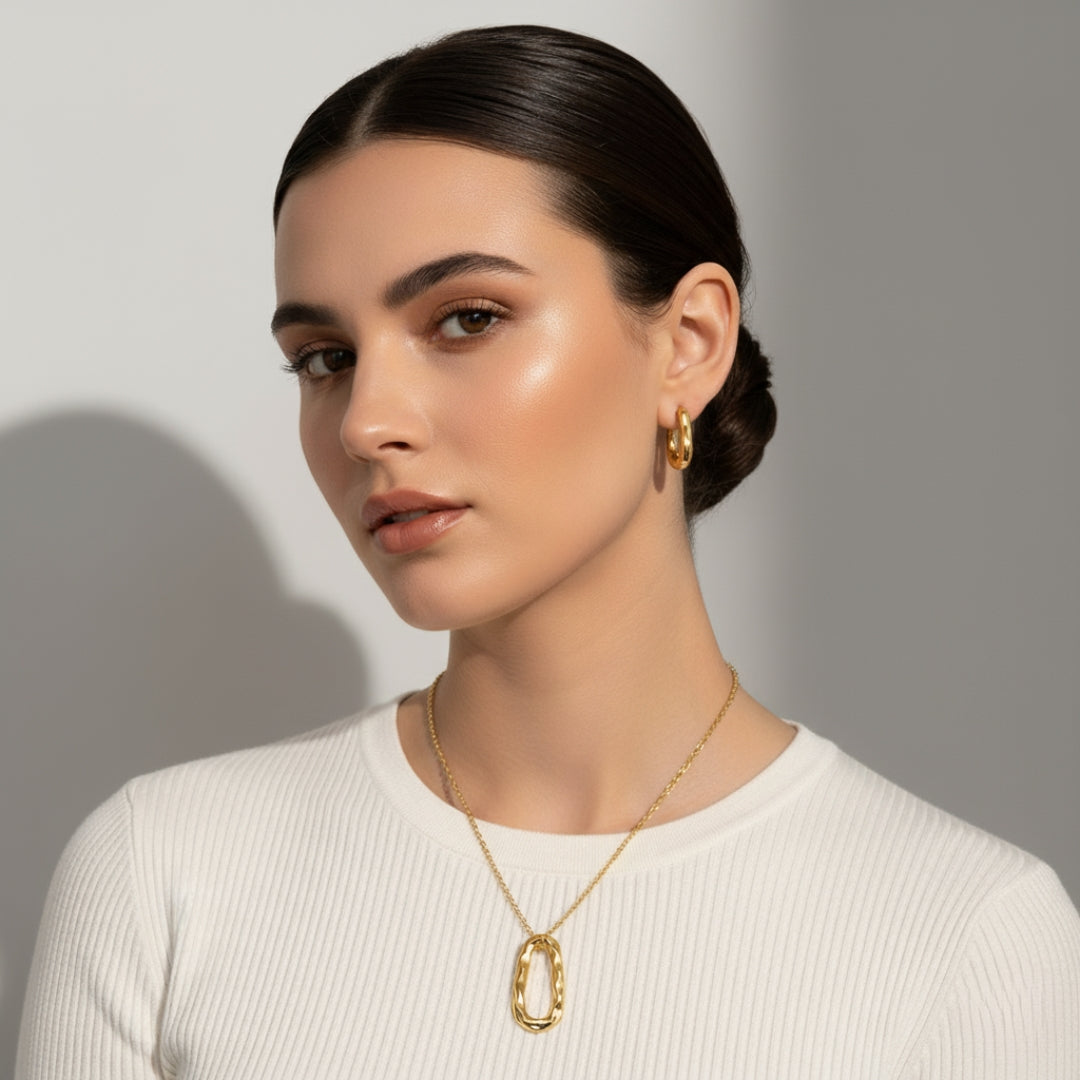 Woman wearing gold jewelry against a neutral background