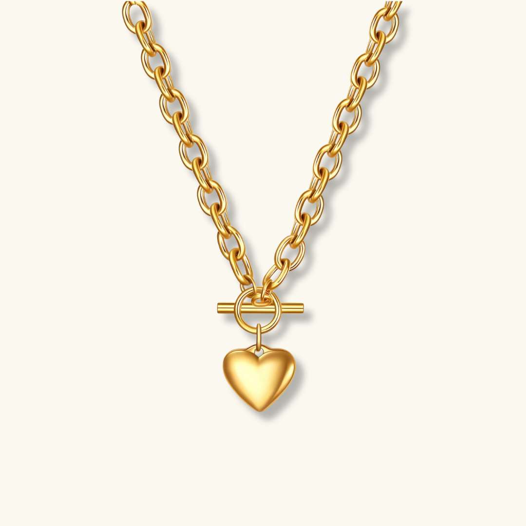 Gold necklace with a heart-shaped pendant on a white background