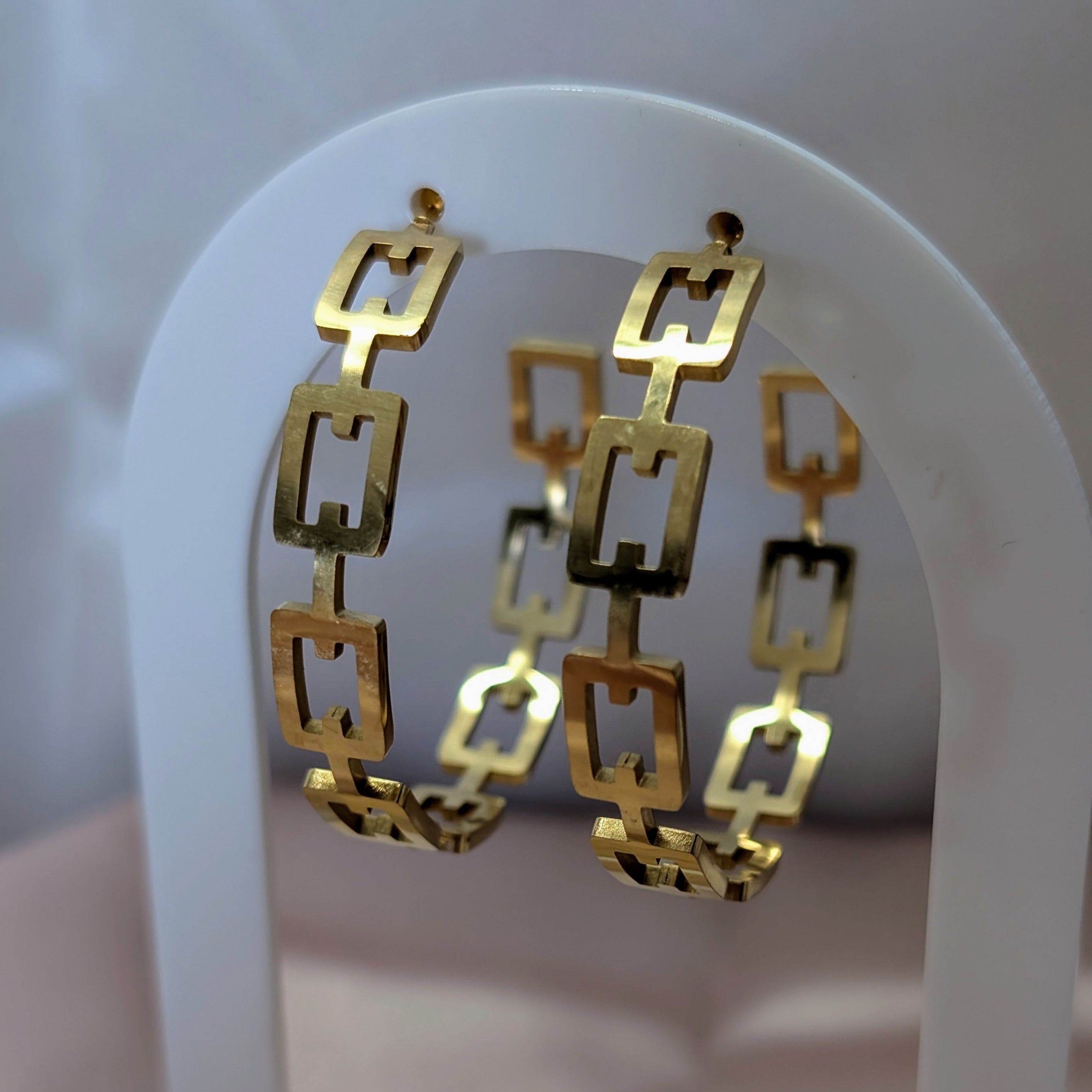 Gold hoop earrings on a white archway