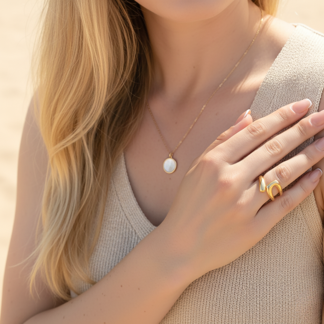 Woman wearing a gold necklace and open gold ring