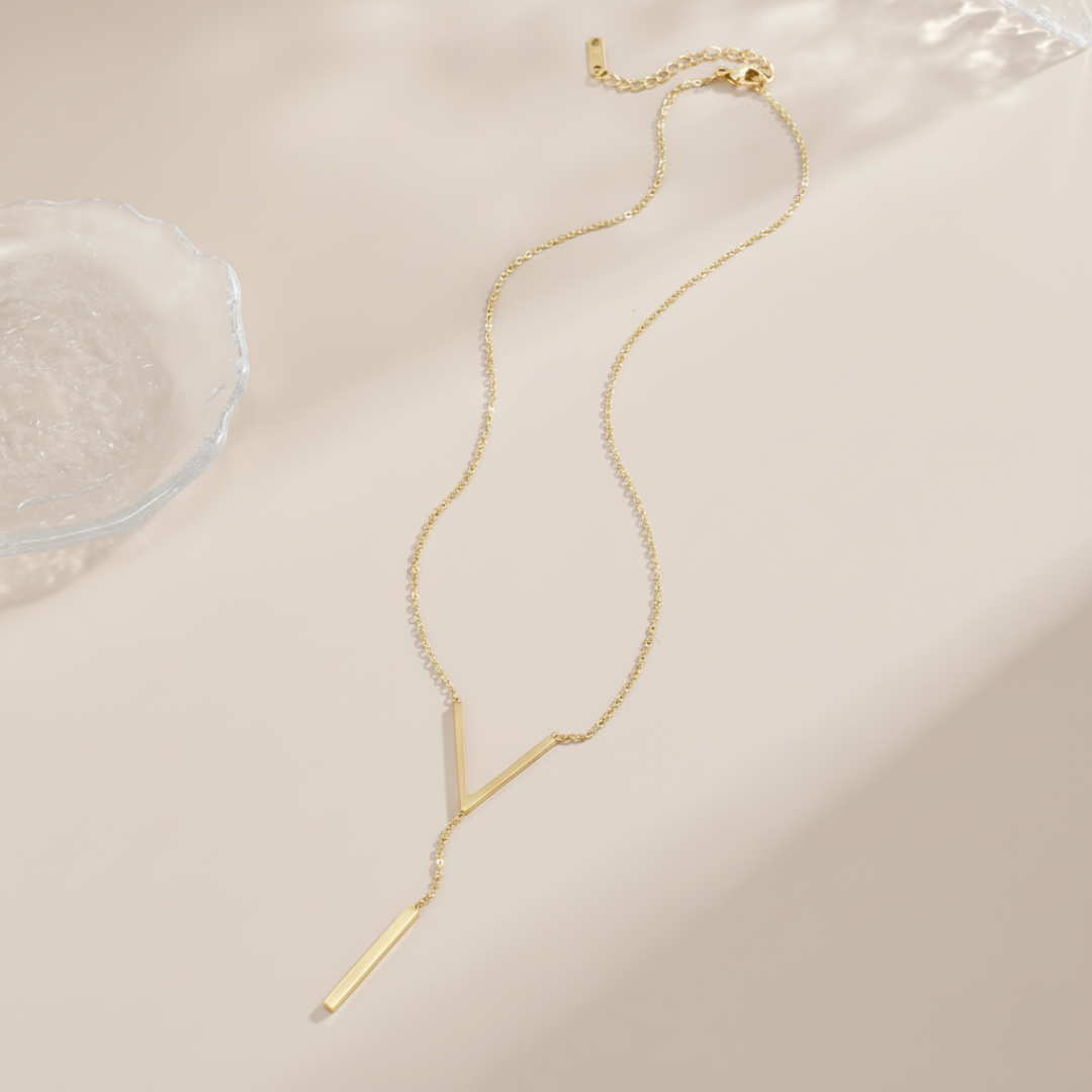 Gold necklace on a beige surface