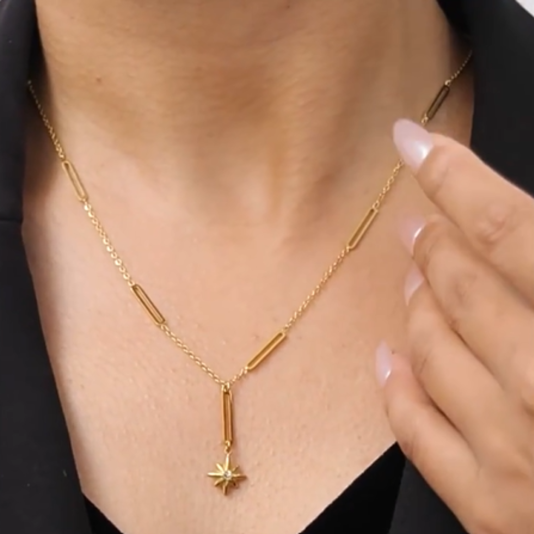 Gold necklace with a star pendant worn by a person