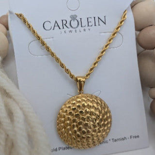 Gold necklace on a CAROLEIN jewelry card held by hands.