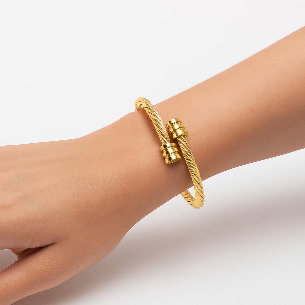 Gold bracelet on a wrist against a light background