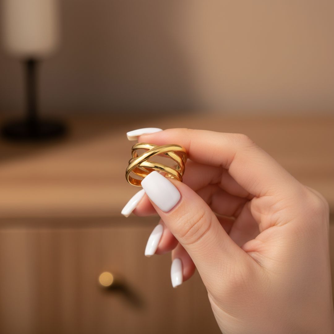 Hand holding a gold ring with a blurred background
