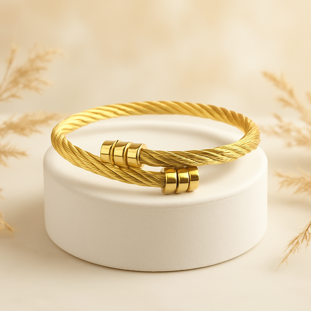 Gold bracelet on a white stand with a soft beige background