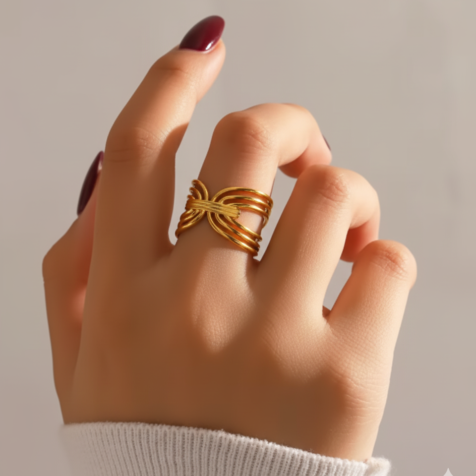 Hand wearing a gold ring on a neutral background