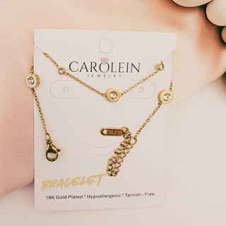 Gold bracelet on a CAROLEIN Jewelry card with a pink background