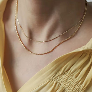 Gold necklace on a person wearing a yellow top