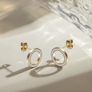 Gold hoop earrings with embedded diamonds on a light background