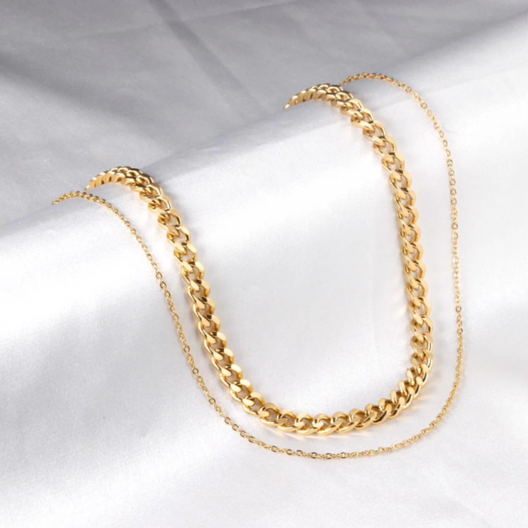 Gold chain necklace on a light gray background