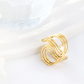 Gold ring with a wavy design on a white background