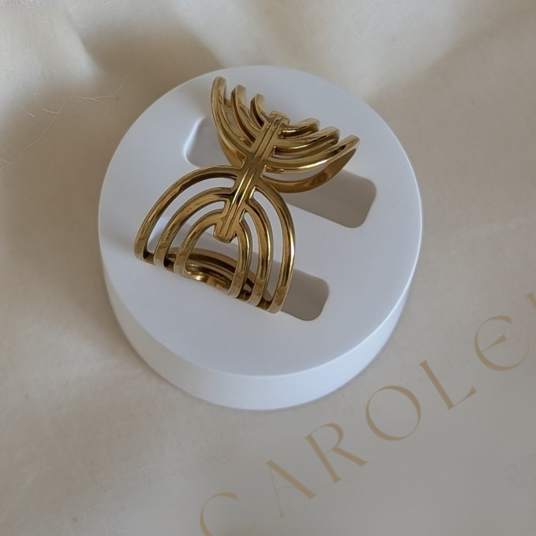 Gold RING on a white stand with 'Carolein" branding in the background