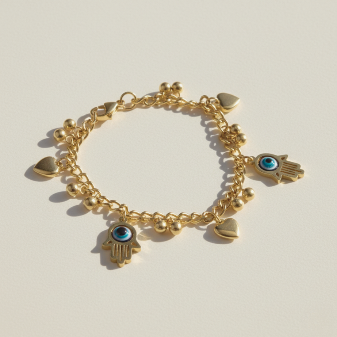 Gold bracelet with various charms on a light beige background