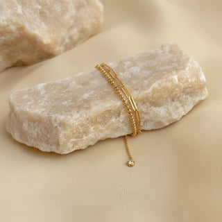 Gold bracelet on a rough stone surface