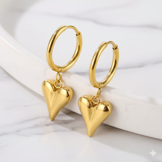 Gold hoop earrings with heart-shaped pendants on a white background