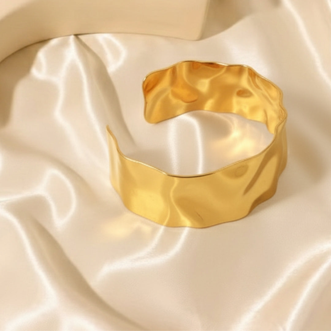 Gold bracelet on a textured beige fabric background