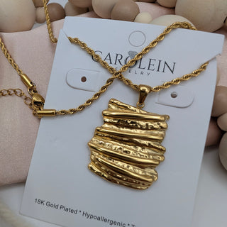 Gold necklace on a display card with 'Carolein' branding, set against a neutral background.