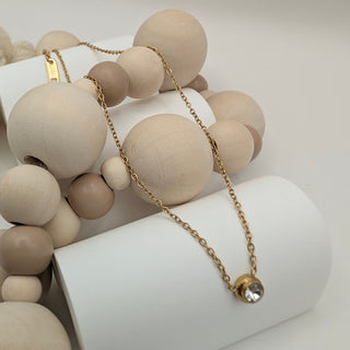 Necklace with wooden beads on a white cylindrical stand