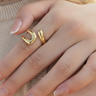 Gold ring on a finger with a neutral background