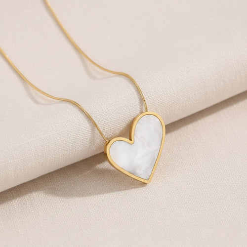 Heart-shaped pendant necklace on a beige fabric background