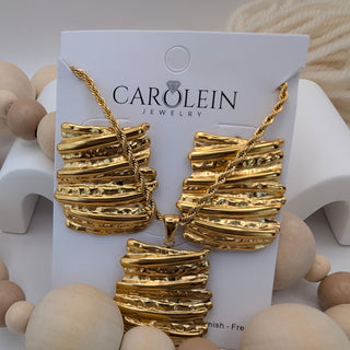 Gold jewelry set on a Carolein Jewelry card with wooden beads in the foreground.