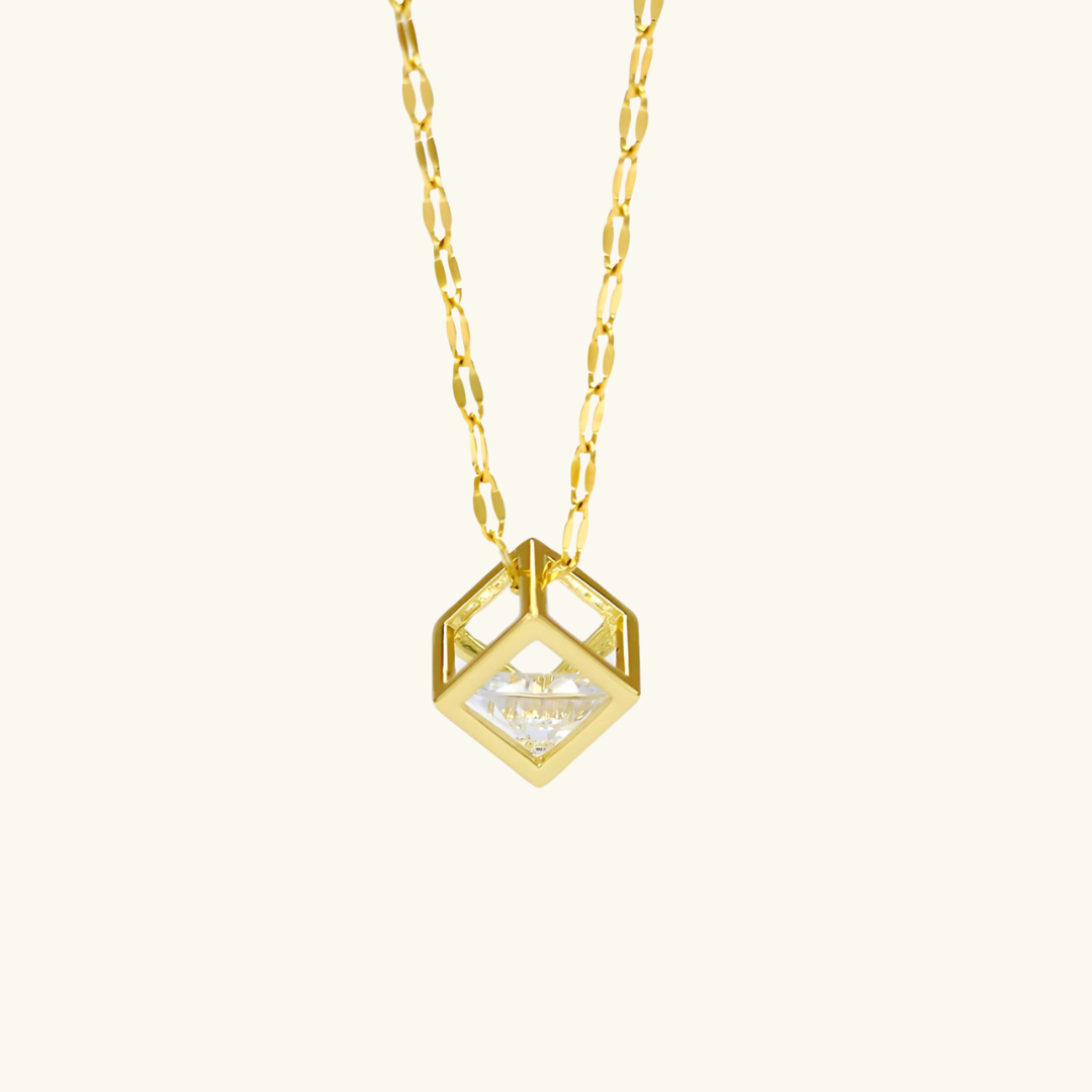 Gold necklace with a geometric pendant on a white background