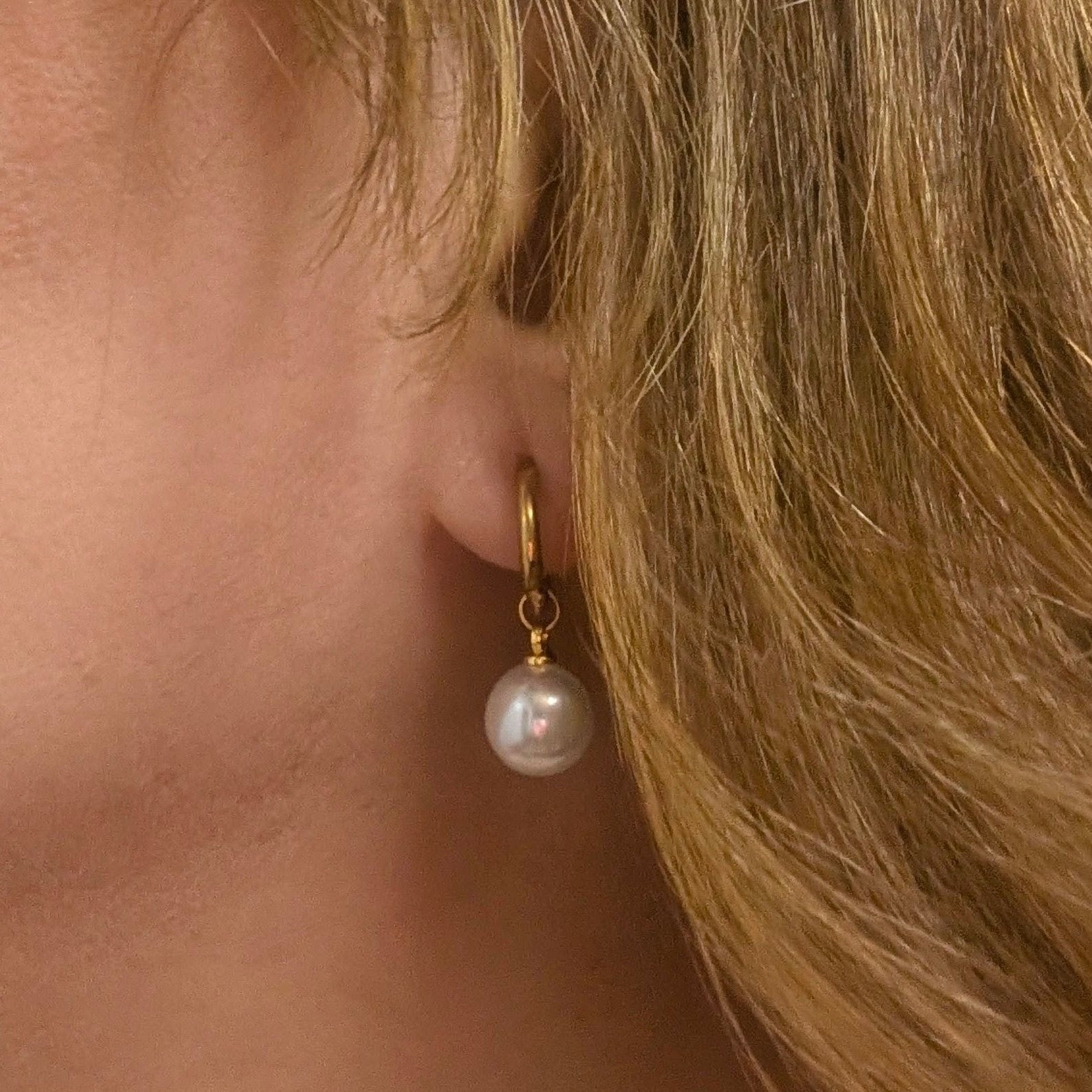Pearl earring worn by a person with blonde hair