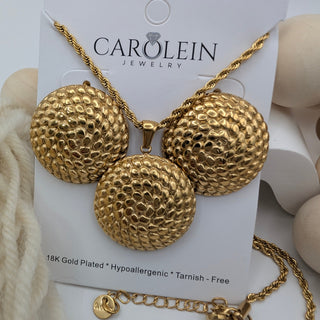 Gold necklace with textured spherical pendants on a Carolein Jewelry card.