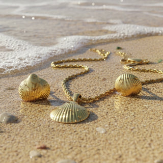 Gold necklace with shell pendants on a sandy beach