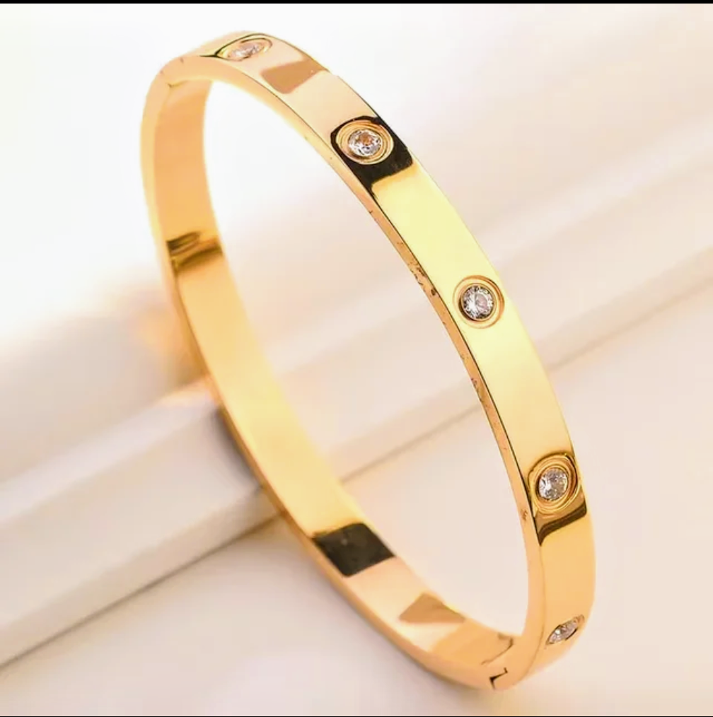 Gold bracelet with diamond accents on a light background