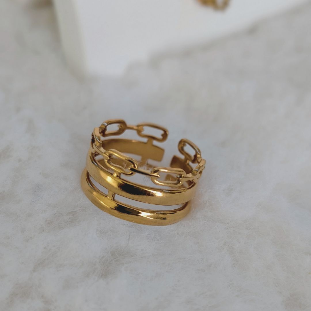 Gold chain ring on a light marble background
