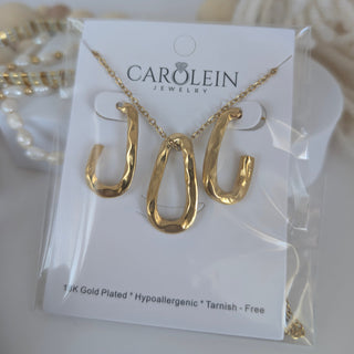 Gold necklace on a 'Carolein Jewelry' card with a white background