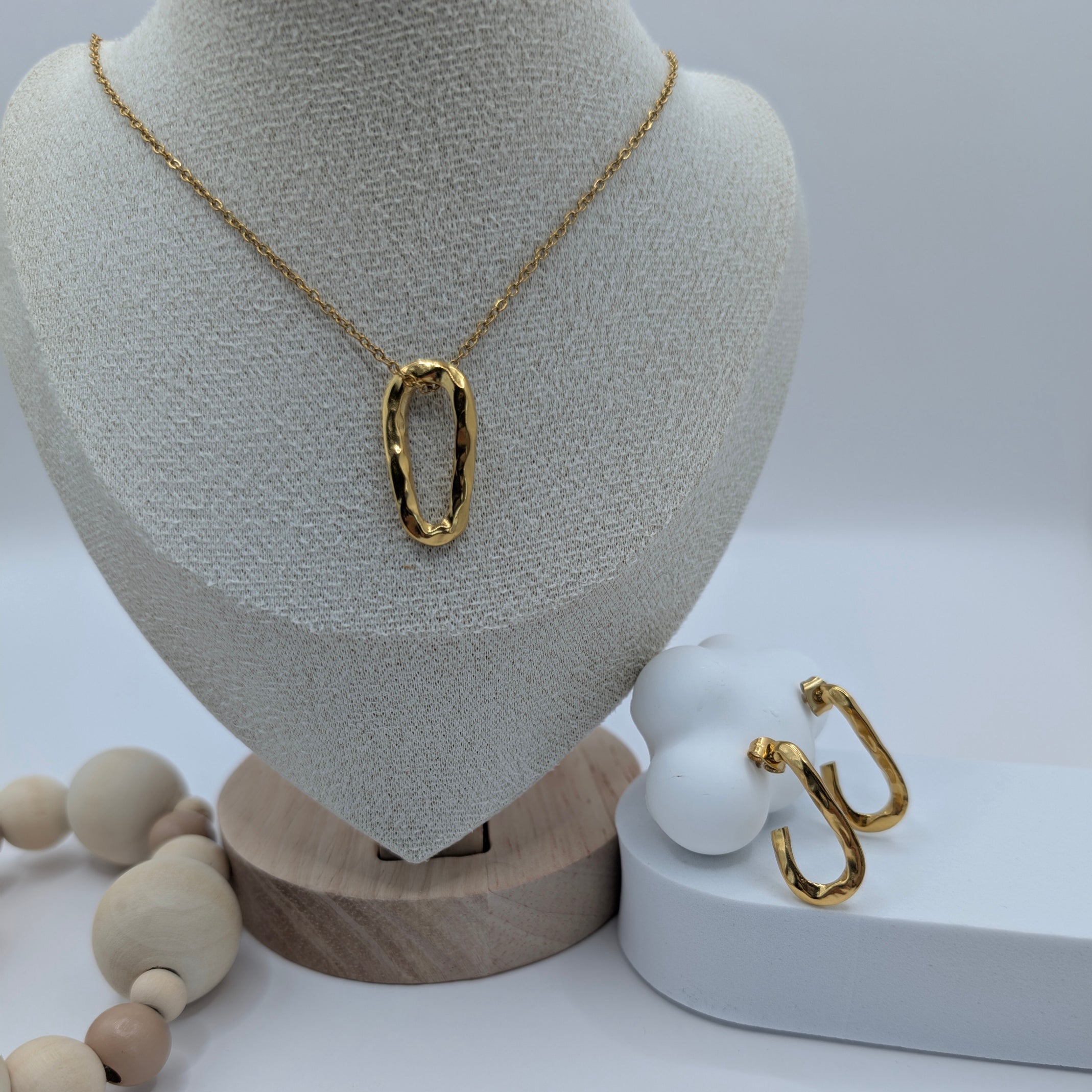 Gold necklace on a mannequin bust with a white background